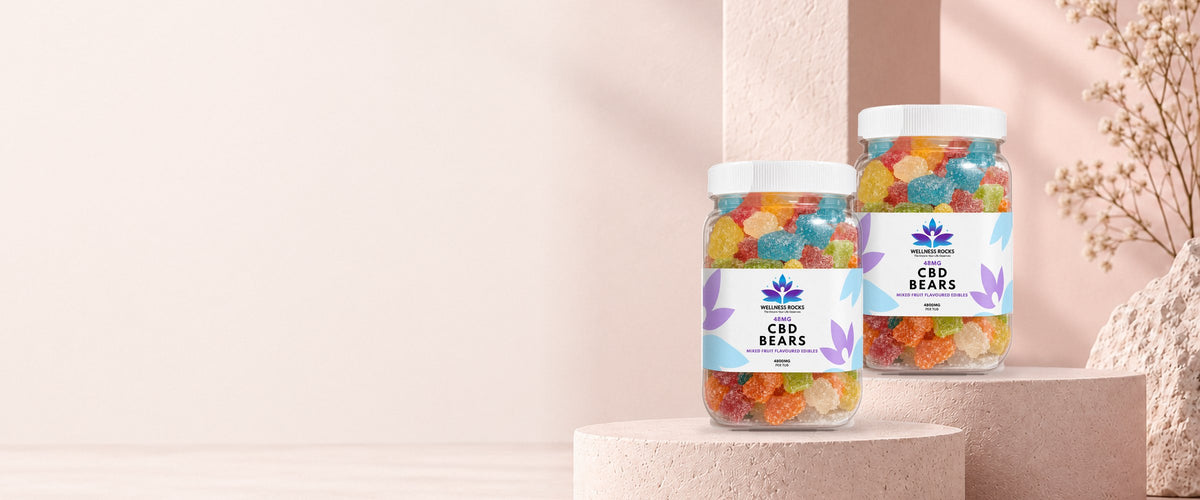 Two tubs of Feminapause Extra Strength CBD Gummies on soft blush plinths